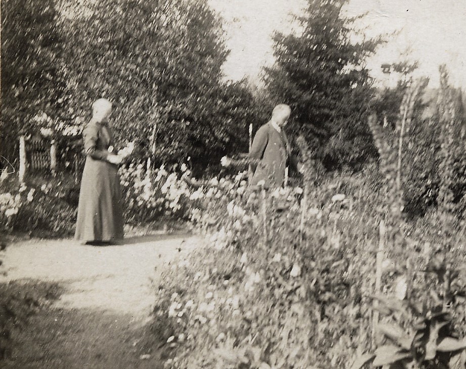 Vanha valokuva. Mies ja nainen rehevässä puutarhassa. Mustavalkoinen.